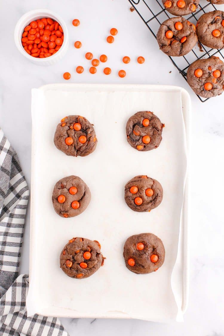 Cake mix cookies on a white tray with some cookies on a wire rack.