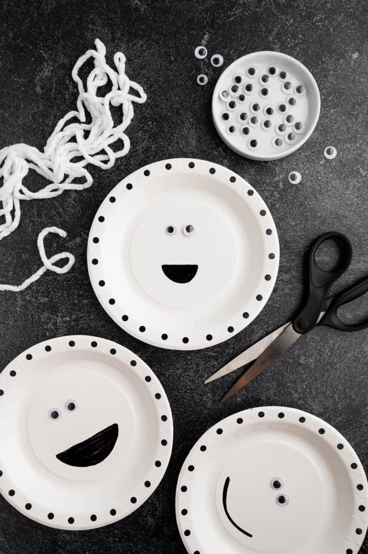 googly eyes glued to center of mummy paper plate craft with string ready to be attached