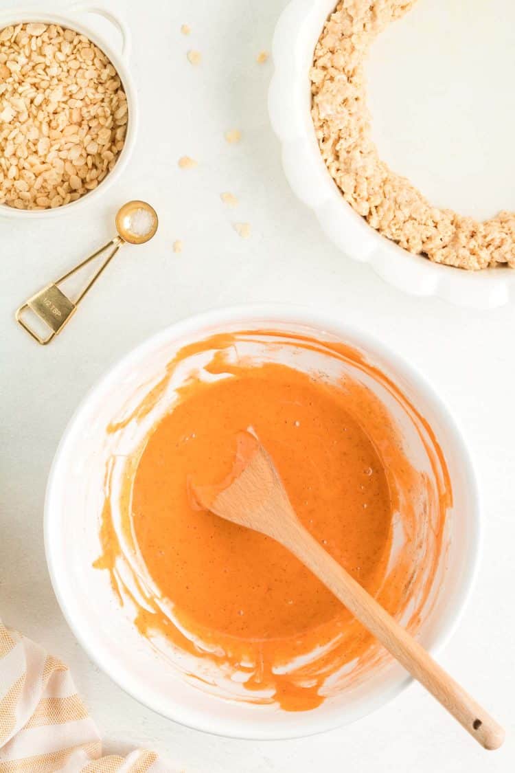 Mixing Pumpkin Pie Rice Krispie Treat Dessert in White Mixing Bowl on White Tabletop