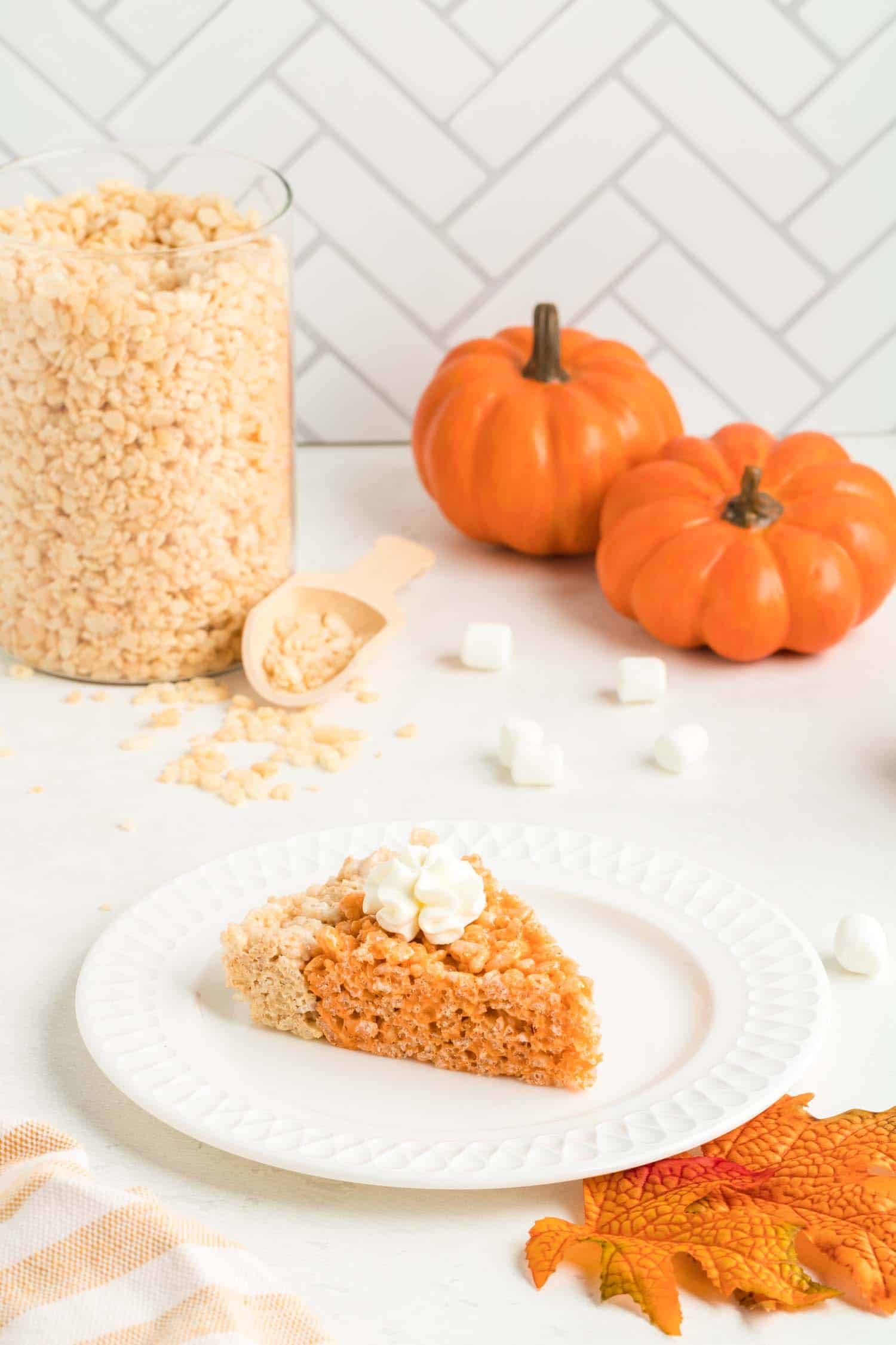 Slice of Pumpkin Pie Rice Krispie Dessert with Pumpkins in Background