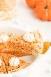 Slice of Pumpkin Pie Thanksgiving Krispie Treat on fork lifted from White Dish