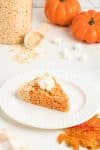 Pie shaped Rice Krispie Treat on a white plate with pumpkins in the background