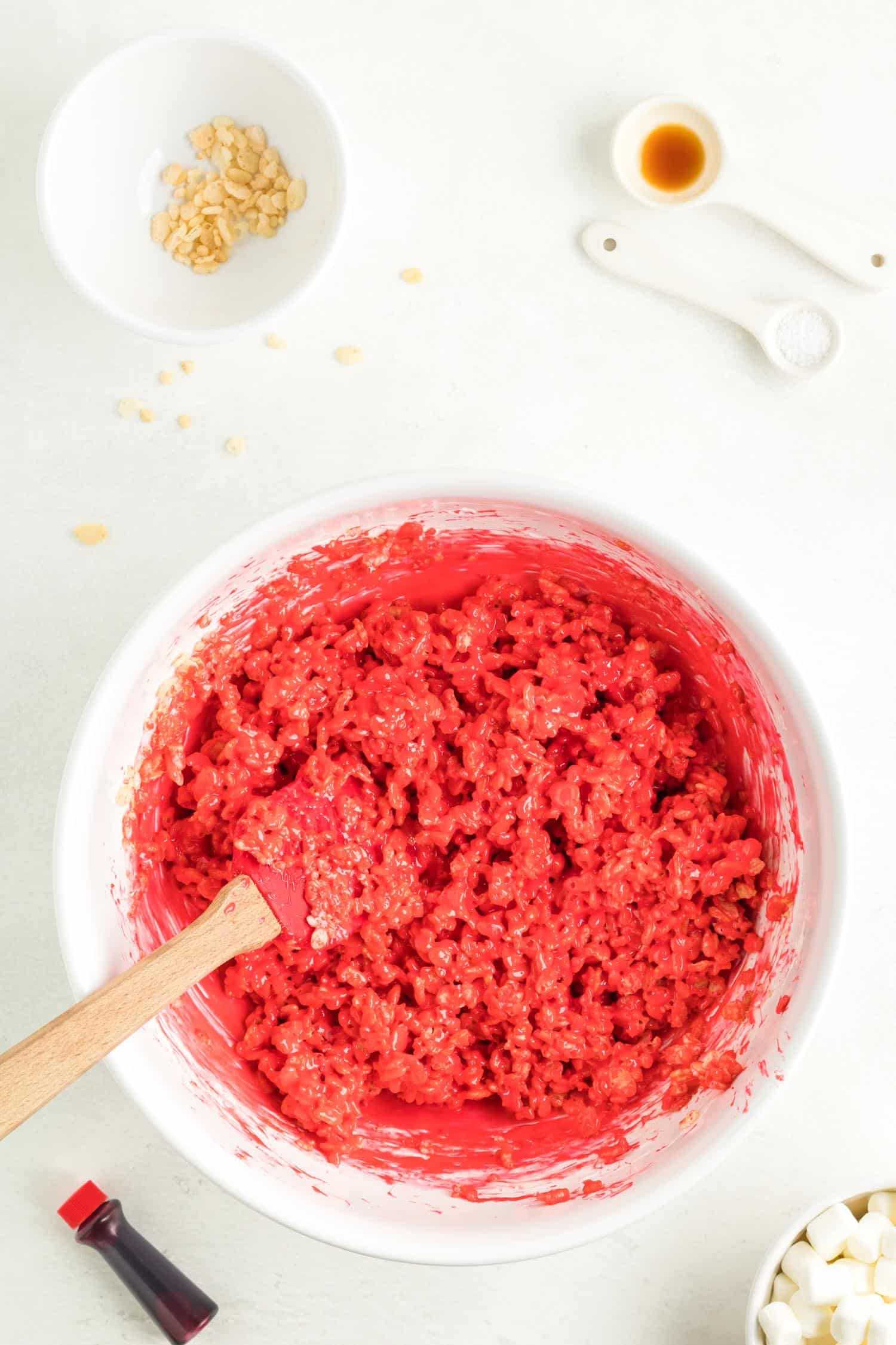 Mixing red food coloring into Rice Krispie treat mixing bowl