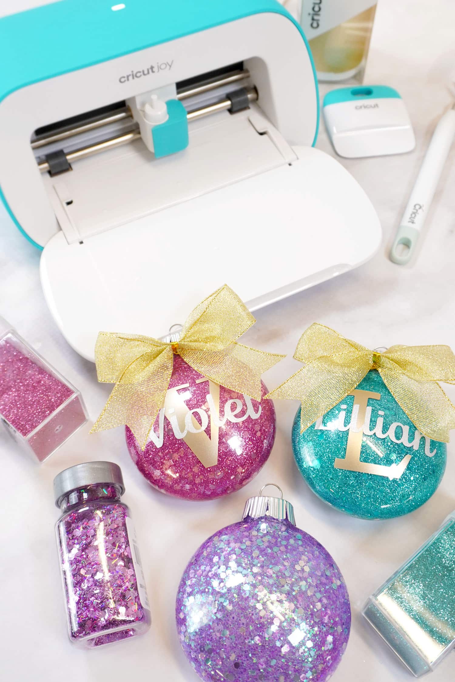 Cricut Joy machine and glitter Christmas ornaments in various colors