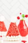 Single red Rice Krispie Treat displayed with red Christmas vase in background