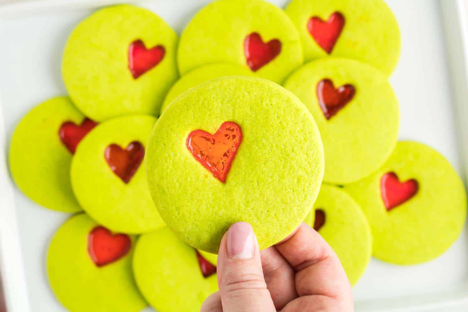 Holding up holiday Grinch cookie