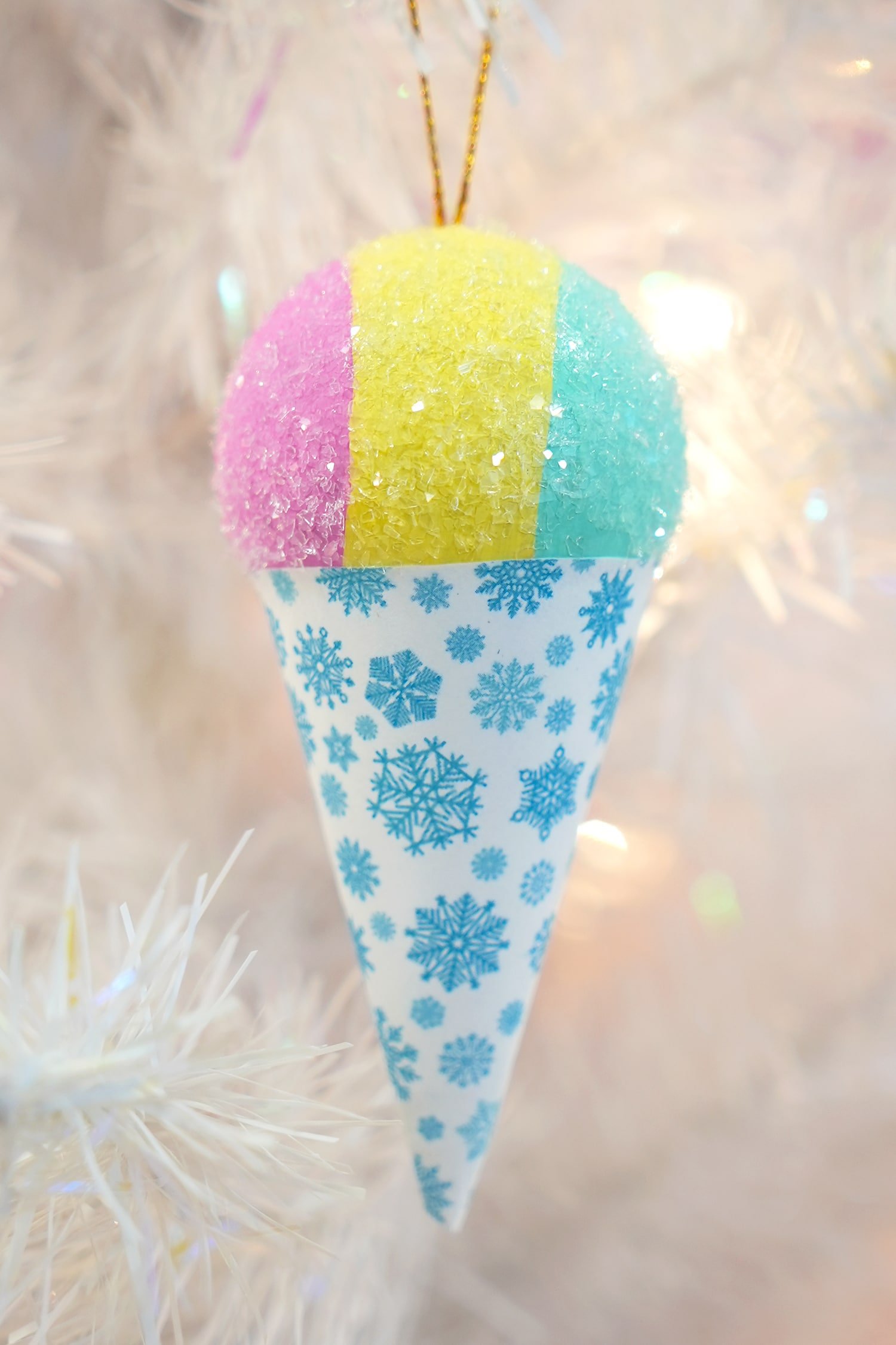 Close-up of sparkly snow cone ornament on a white Christmas tree