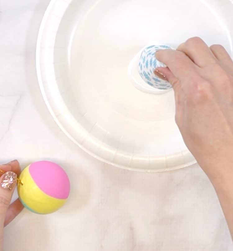 Close up of hands adding glue to the rim of a paper cone