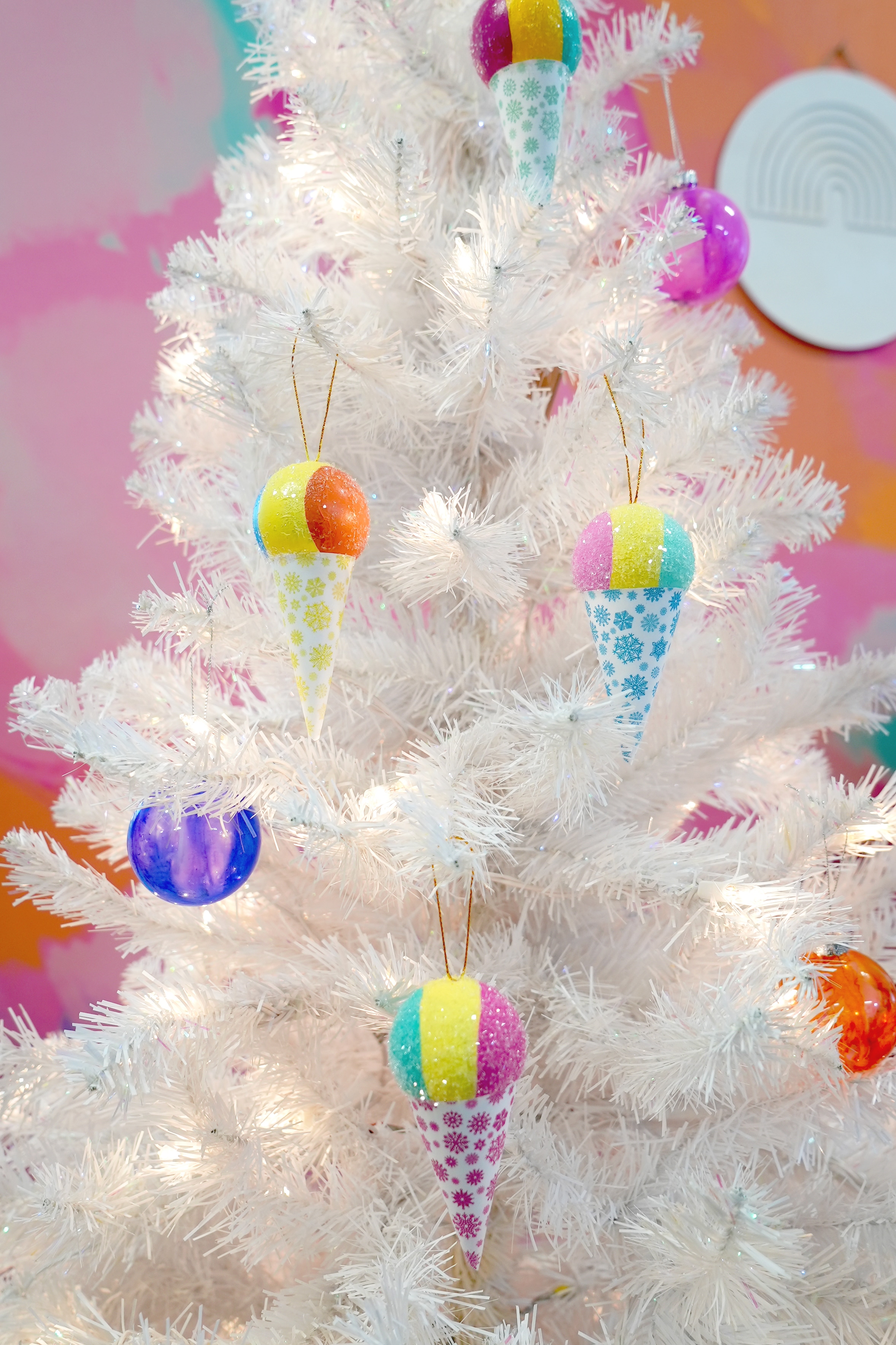White Christmas tree with colorful snow cone Christmas ornaments