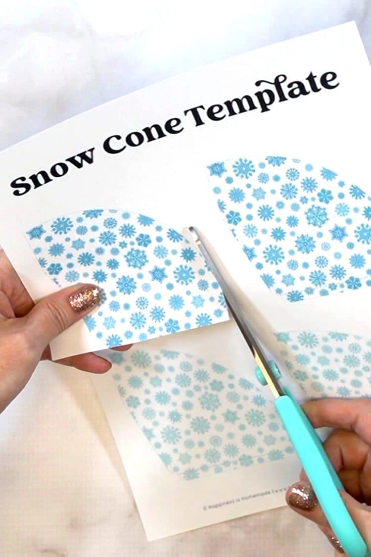 Close up of blue scissors cutting out a snow cone template