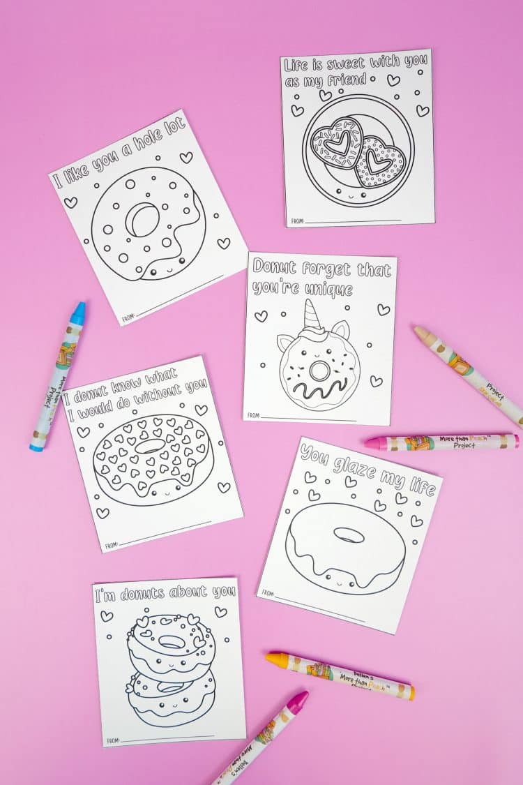 six donut valentine cards on a lavender background with crayons