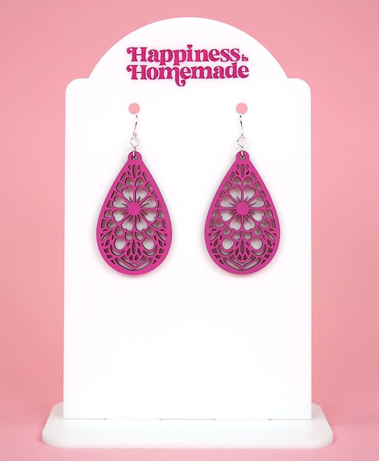pink laser cut dangle drop earrings on white backing with happiness is homemade logo in pink 