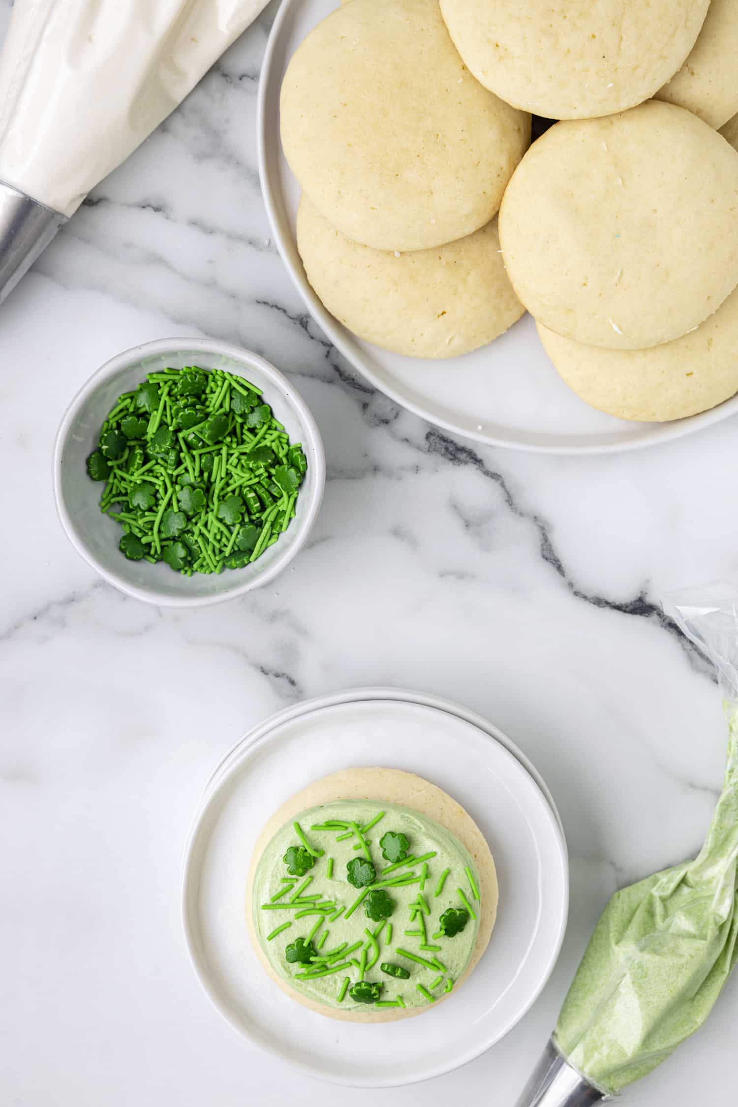 Iced Lofthouse cookie with a platter of plain sugar cookies on plate