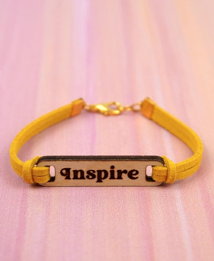 yellow bracelet engraved with the word inspire