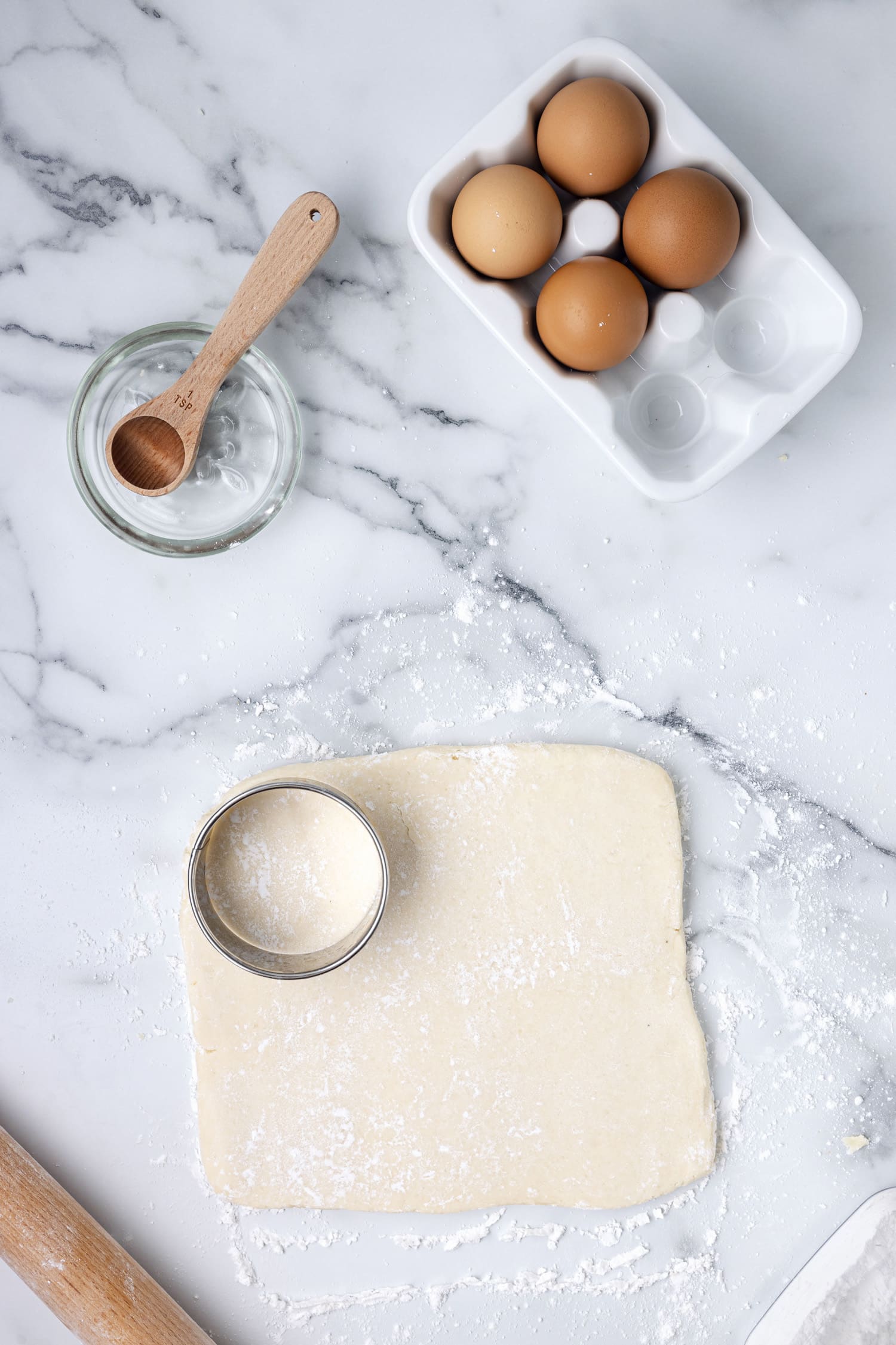 Cookie dough being cut with round cookie cutter