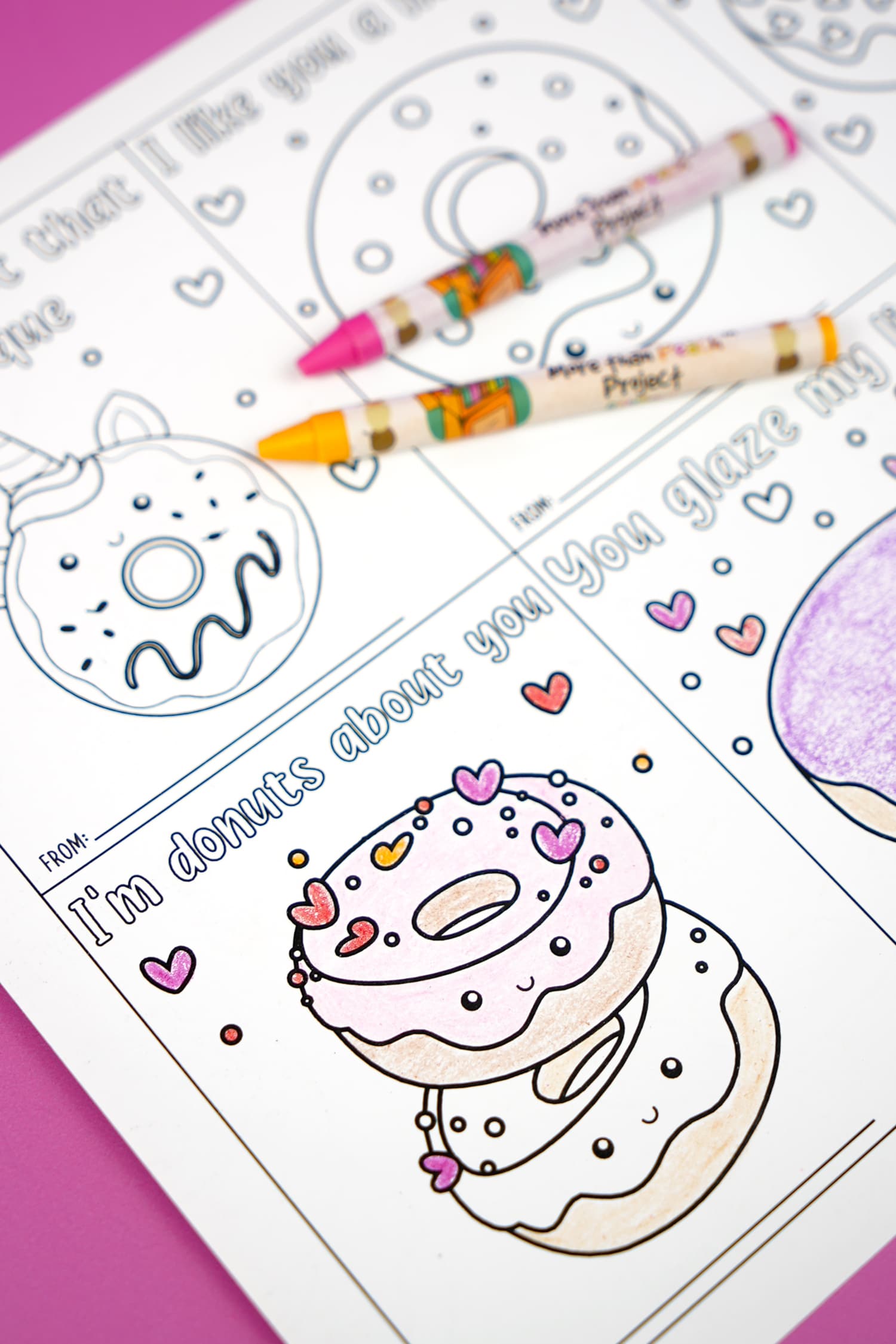 close up of partially colored donut valentine cards with crayons