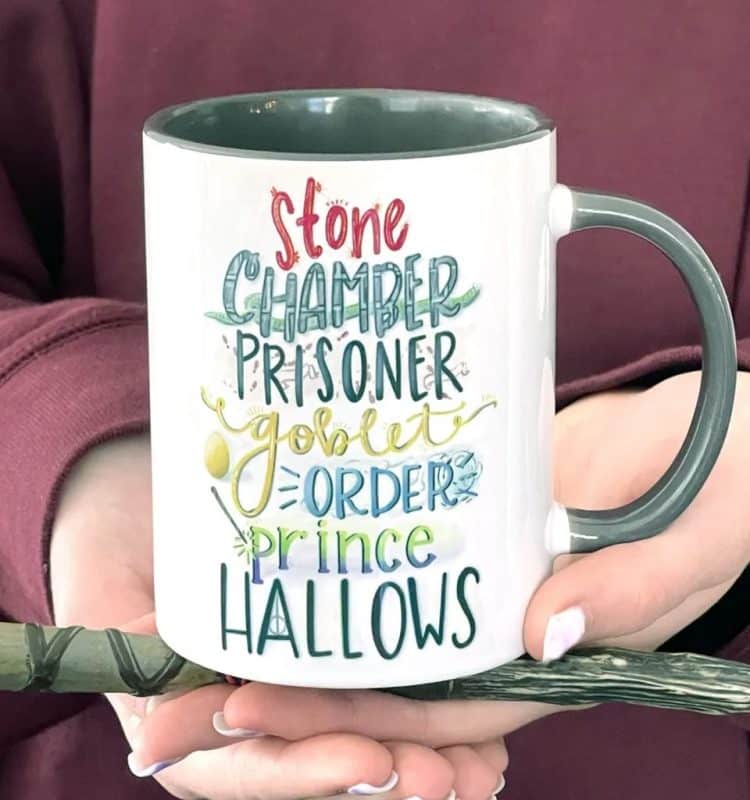 a woman holding a coffee mug with names of harry potter book titles