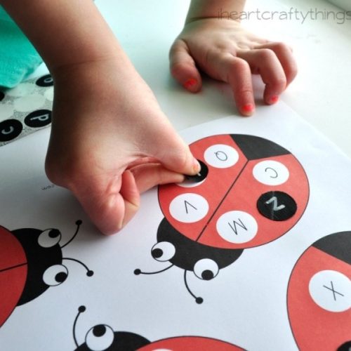kids hand playing ladybug alphabet match
