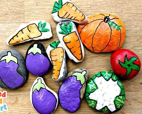 rocks painted like vegetables; carrots, pumpkins, tomato, eggplant