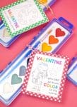Heart-shaped watercolor paint set with printable paint valentine cards for kids on a pink background