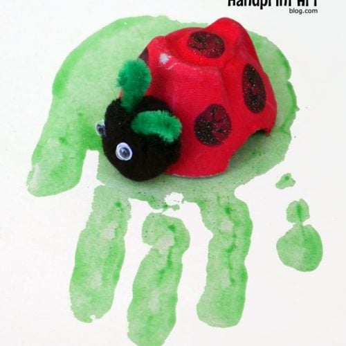 Ladybug made from egg carton on a green handprint
