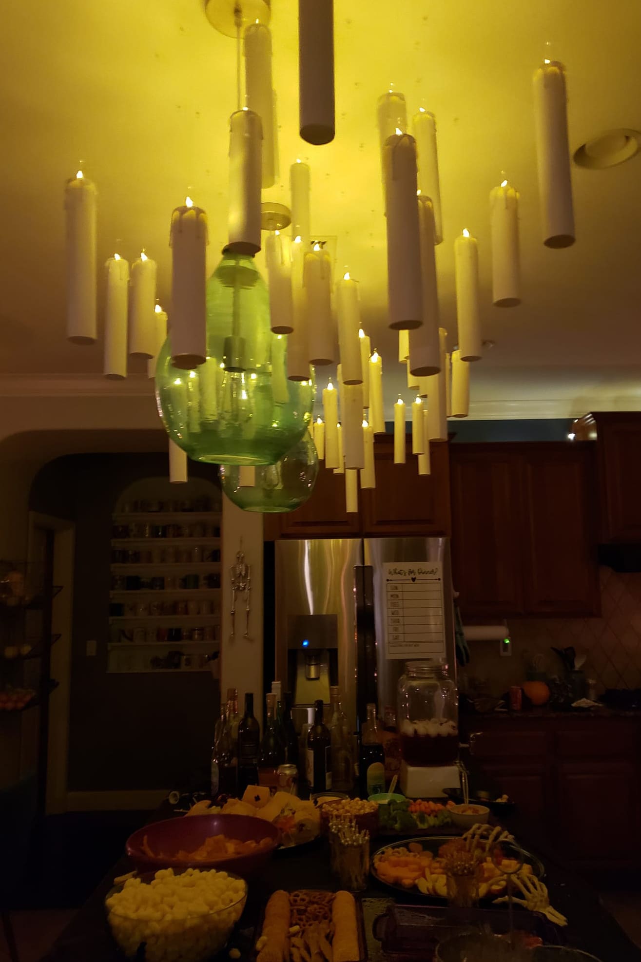Lit Harry Potter floating candles hanging above the food buffet counter at a Halloween party