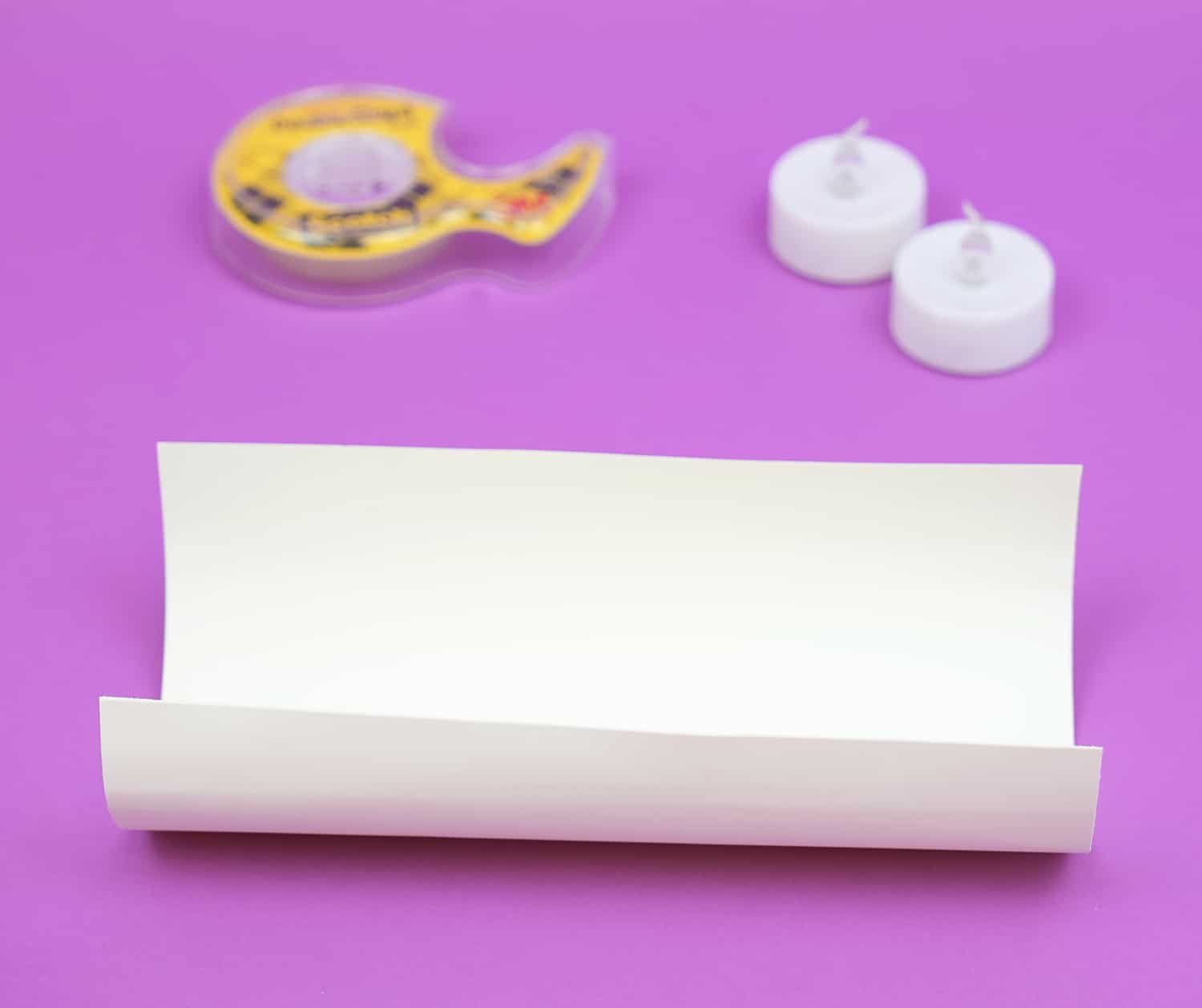 Loosely rolled sheet of white paper on a purple background