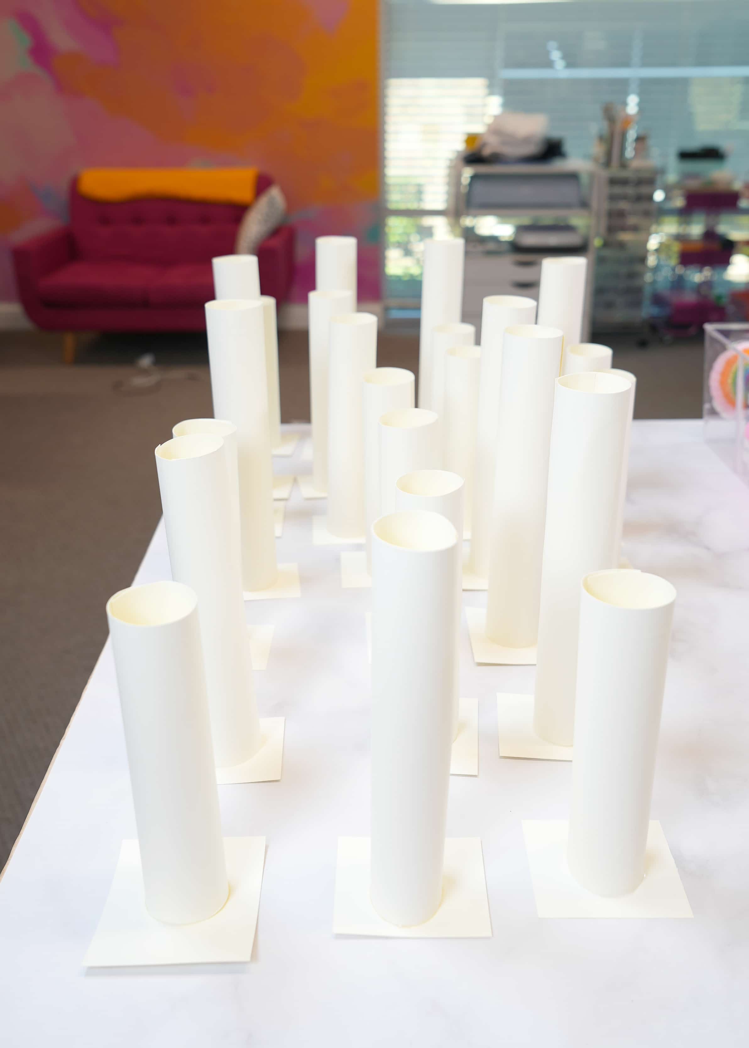 Tubes of paper sitting on top of square paper bases