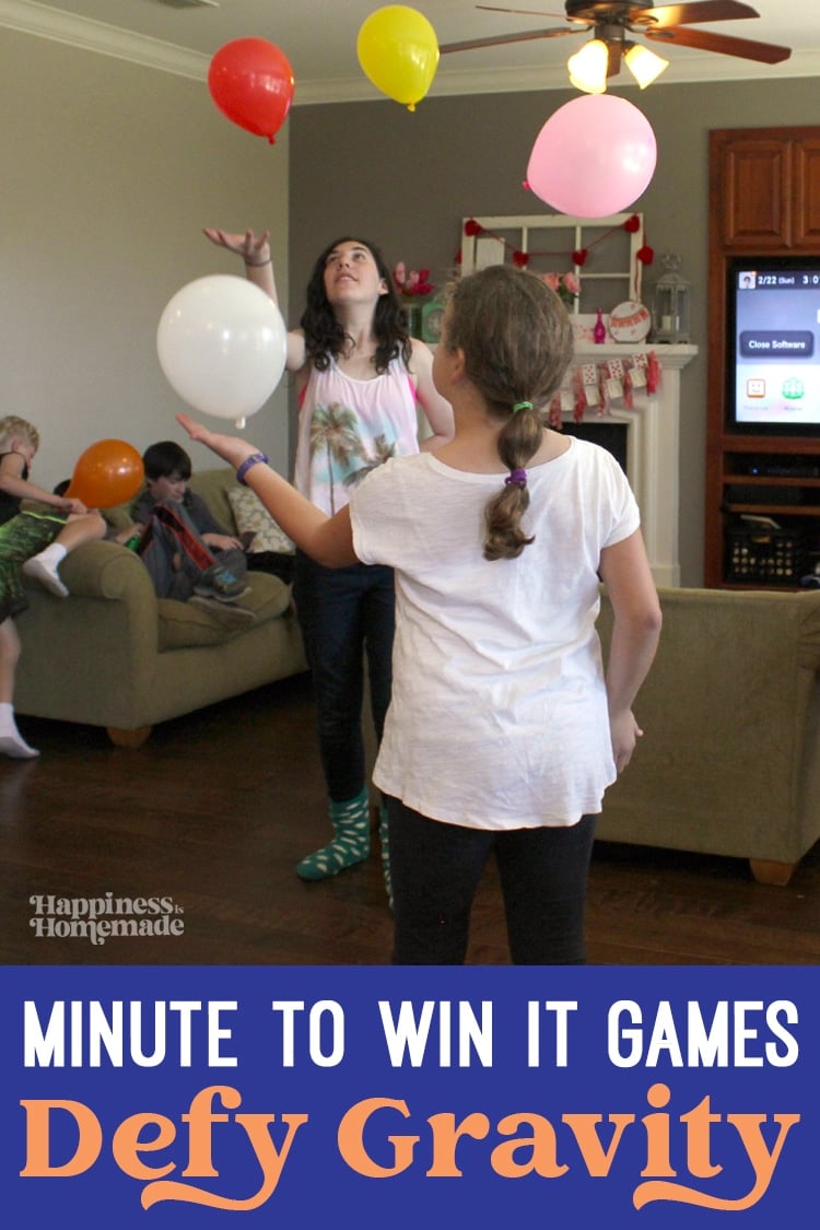 two girls are playing with balloons in the living room for minute to win it games defy gravity