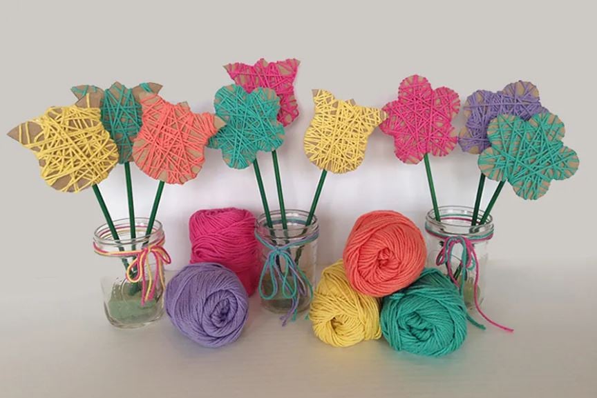 Colorful cardboard and Yarn flowers in mason jar vases