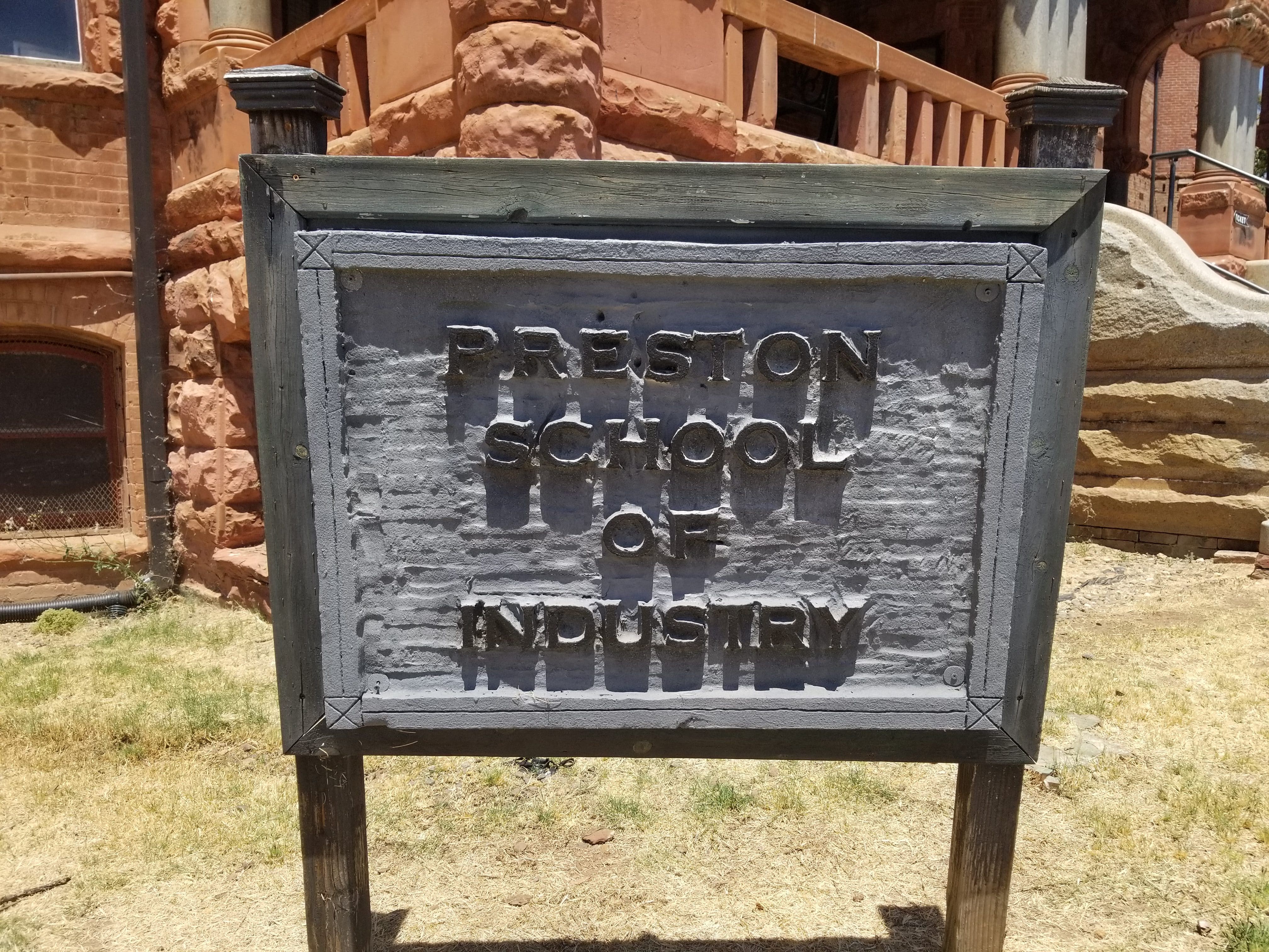 "Preston School of Industry" wooden sign outside of building