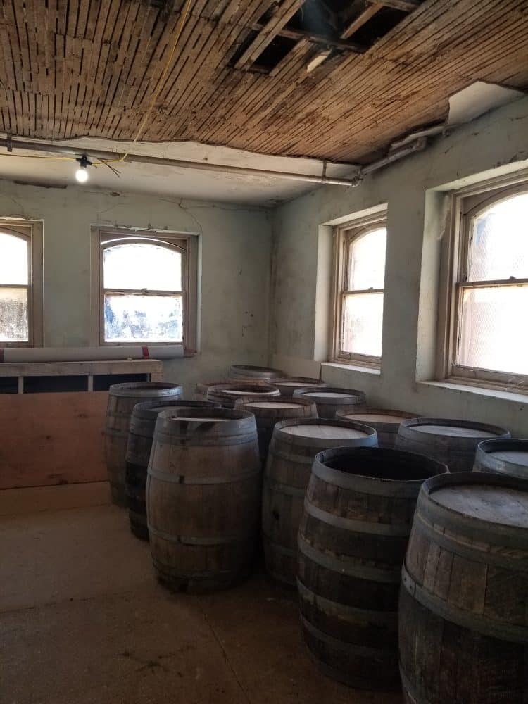 numerous wine barrels being stored in basement