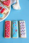Iced sugar cookies with plate of cookies