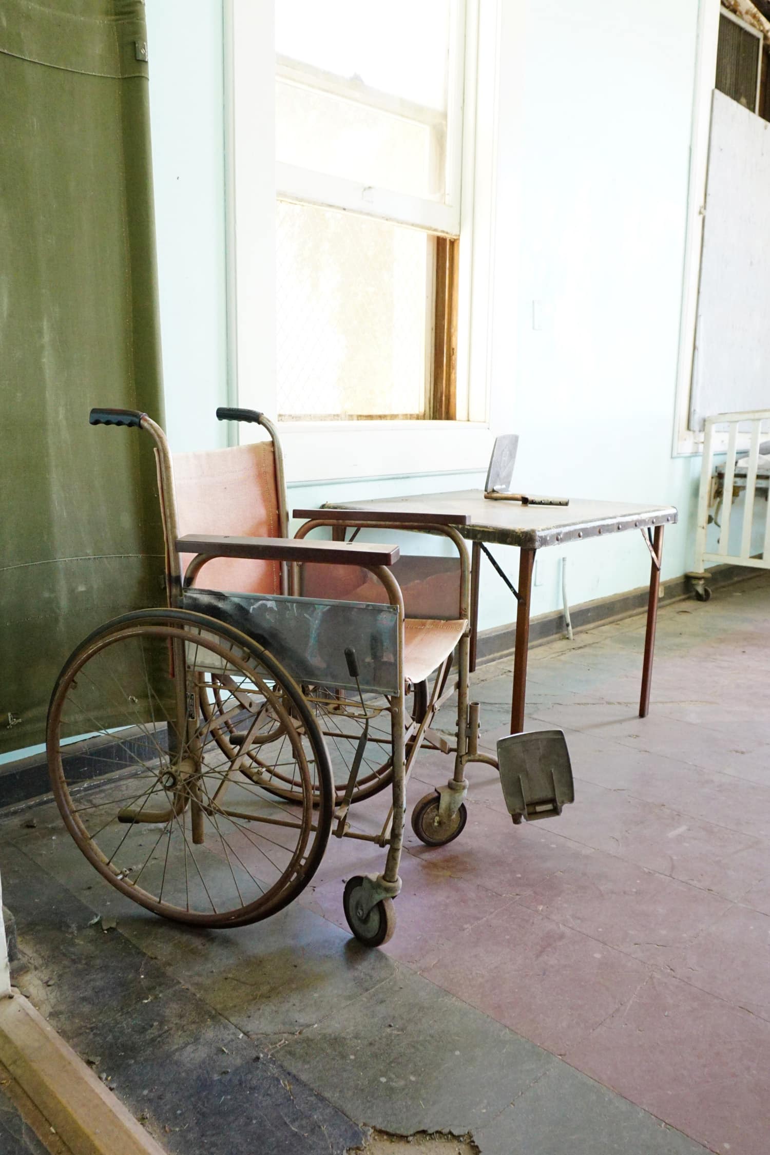 Vintage wheelchair in dusty and dirty old infirmary room 