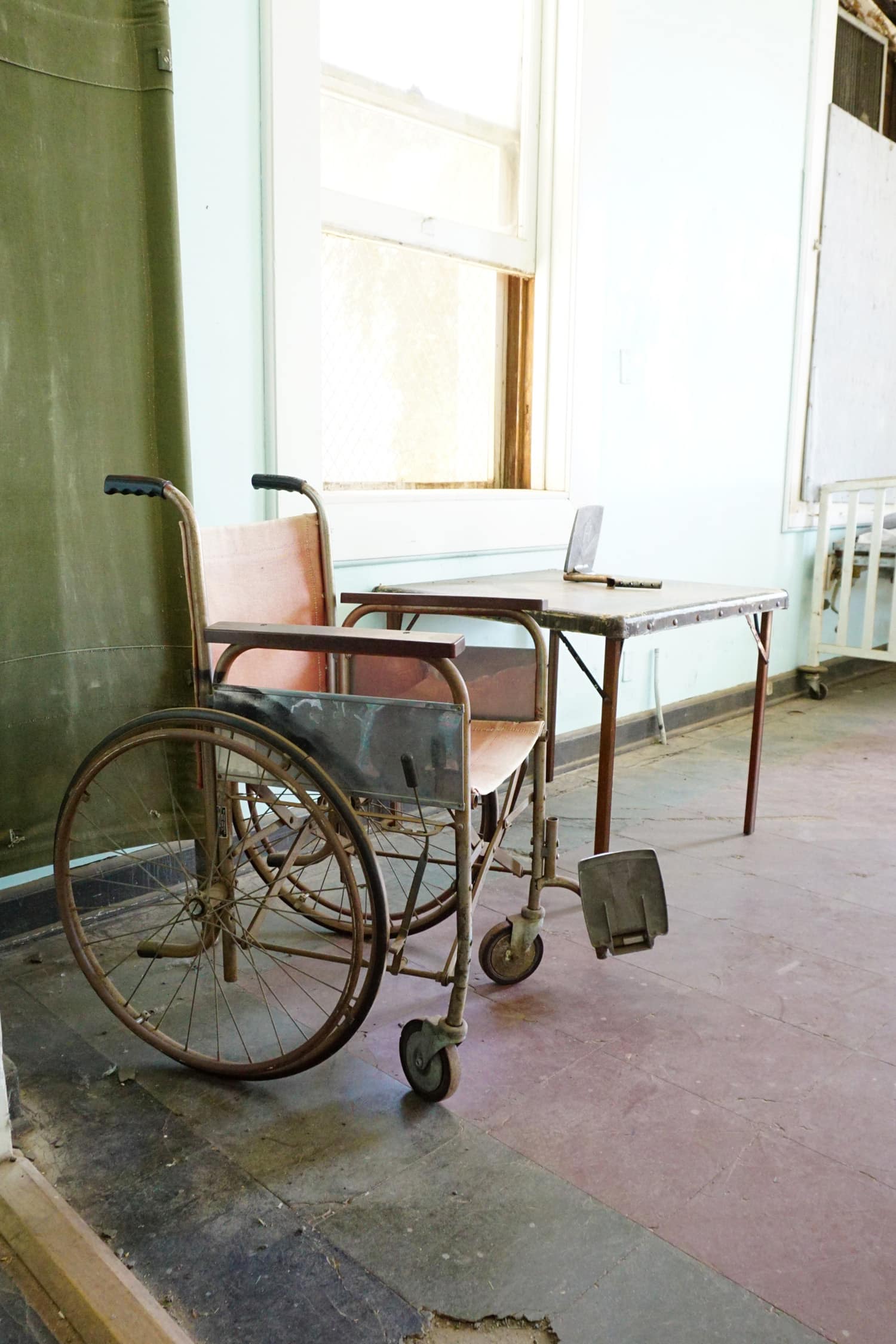Vintage wheelchair in dusty and dirty old infirmary room