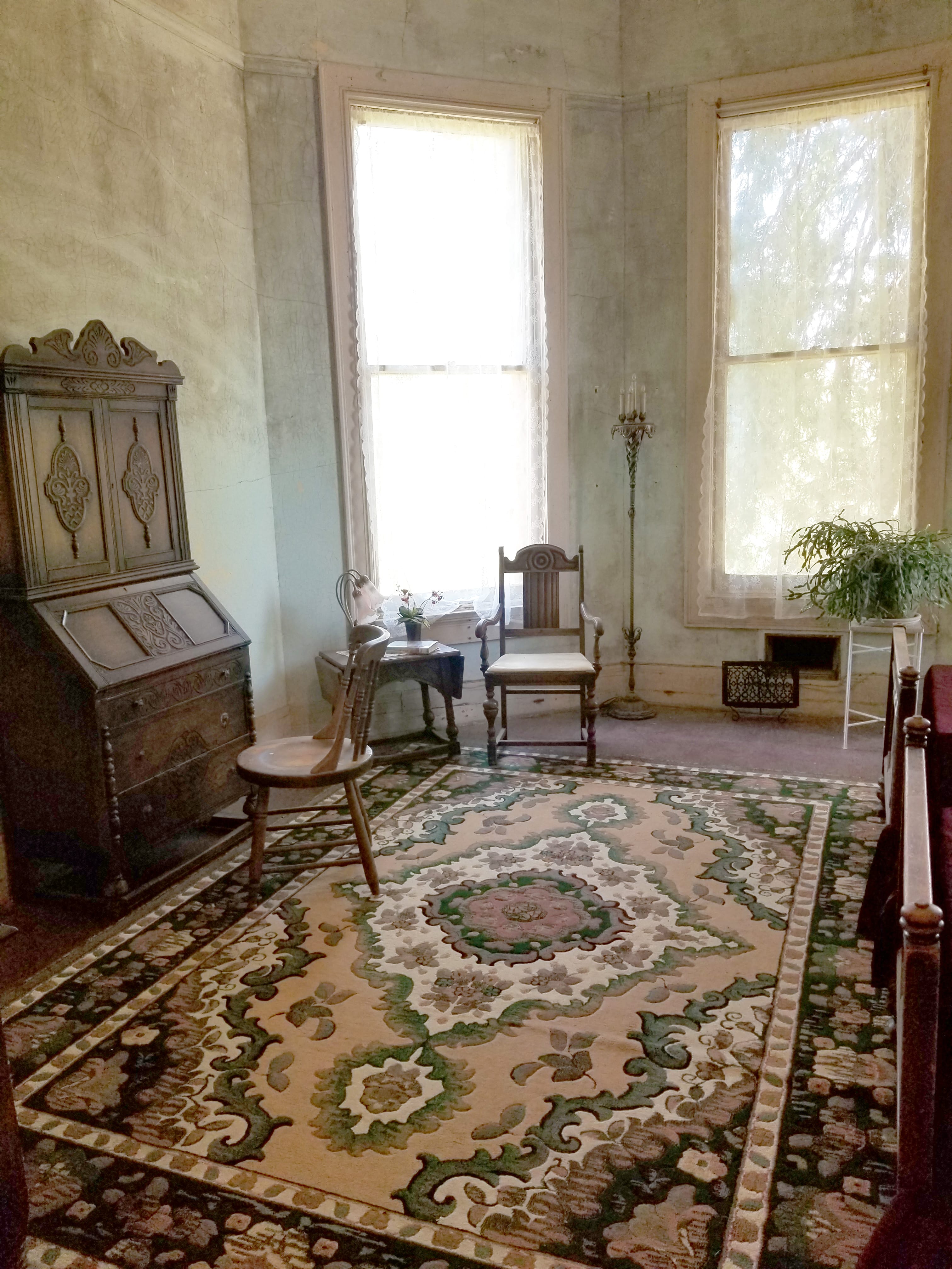 apartment room filled with antique furniture and sheer curtains