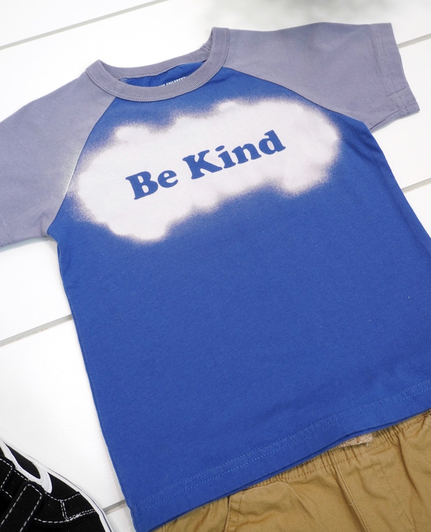 close up of blue "be kind" bleach stenciled shirt design