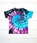 black, blue, and purple spiral tie dye shirt on white wood background