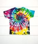 Black and rainbow spiral tie-dye shirt on a white wood background