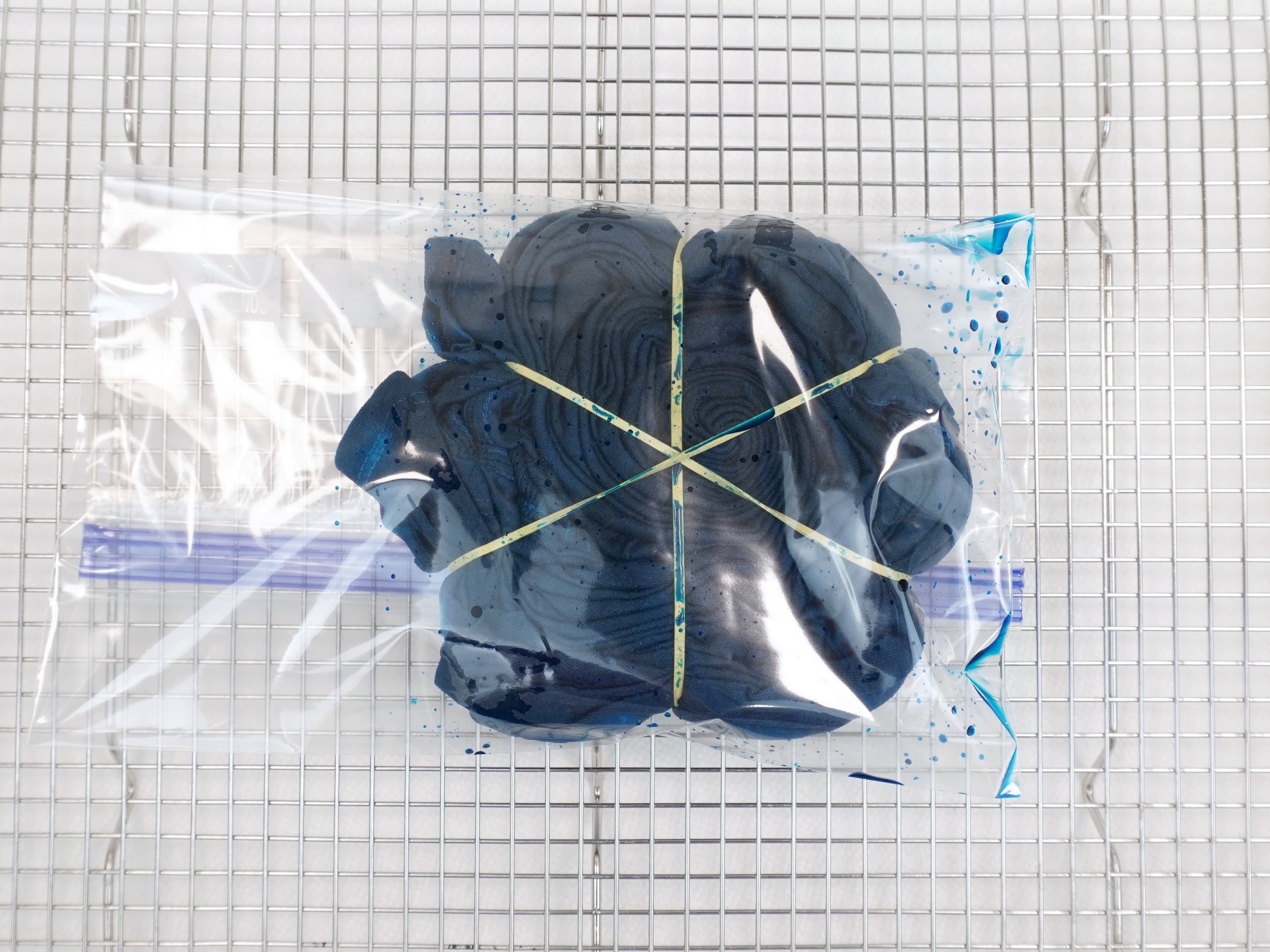 dark teal spiral tie dye shirt in plastic zip bag