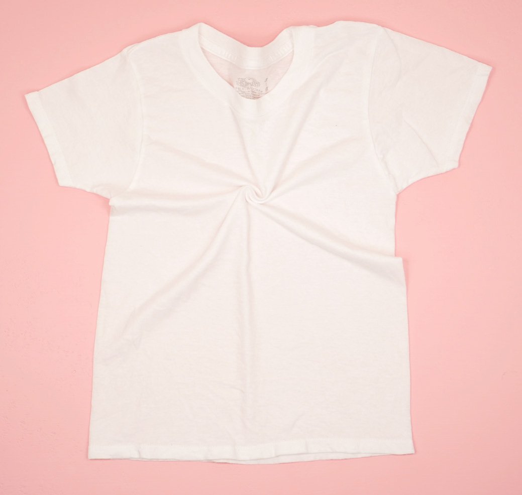 White shirt on pink background with the beginning of a spiral twist in the middle of the chest