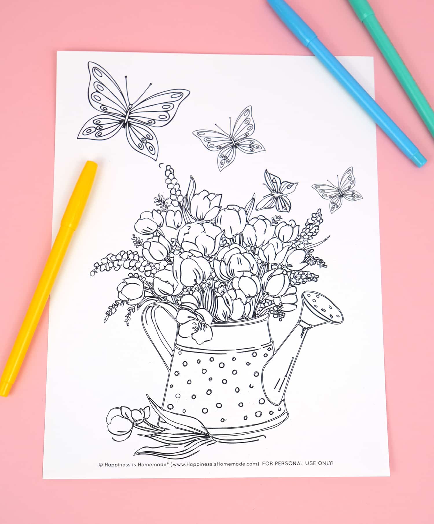 Coloring page featuring butterflies and watering can filled with flowers on pink background with markers