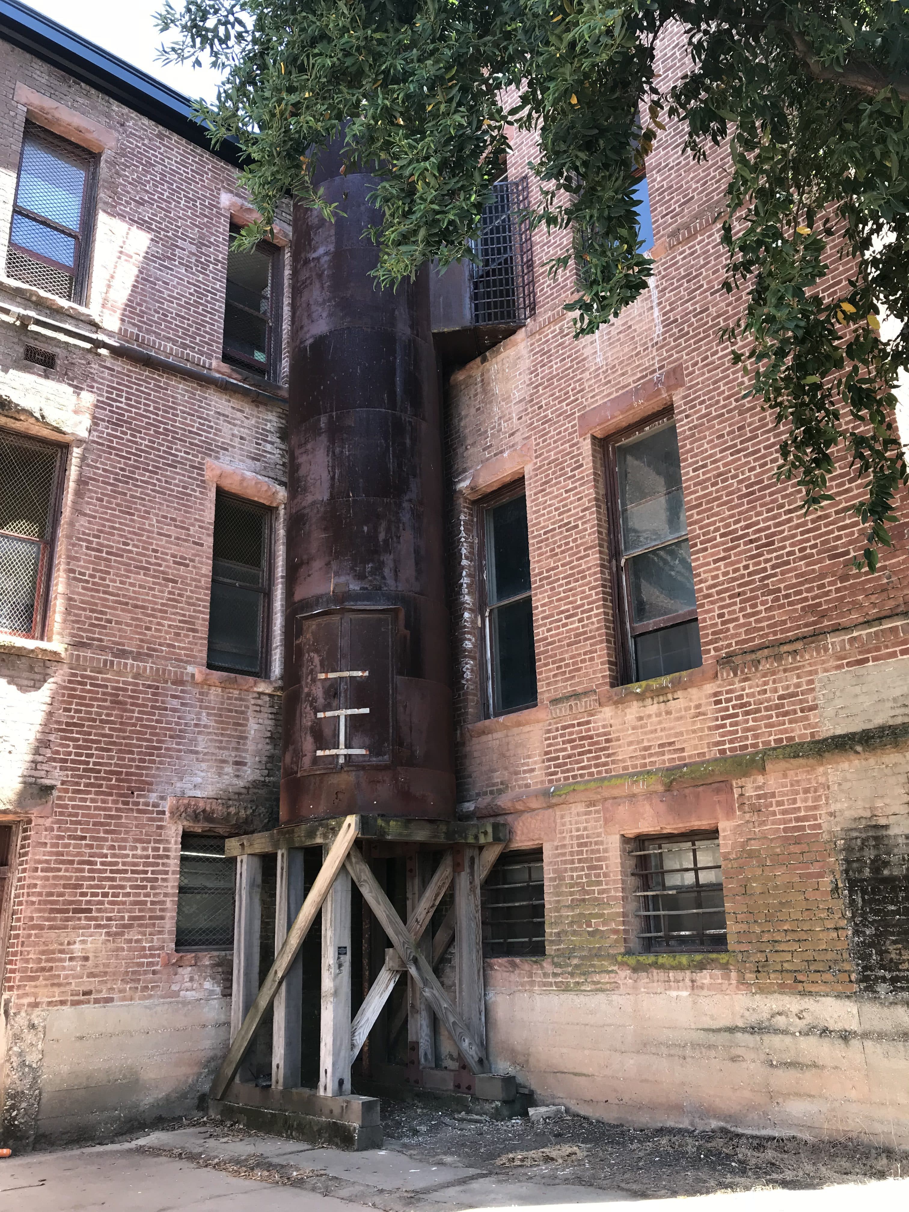 metal fire escape tube on exterior of brick building