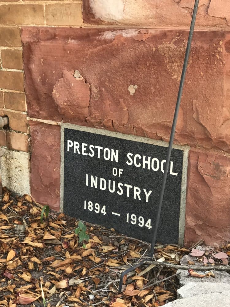 "Preston School of Industry 1894-1994" sign on the wall of the building at ground level