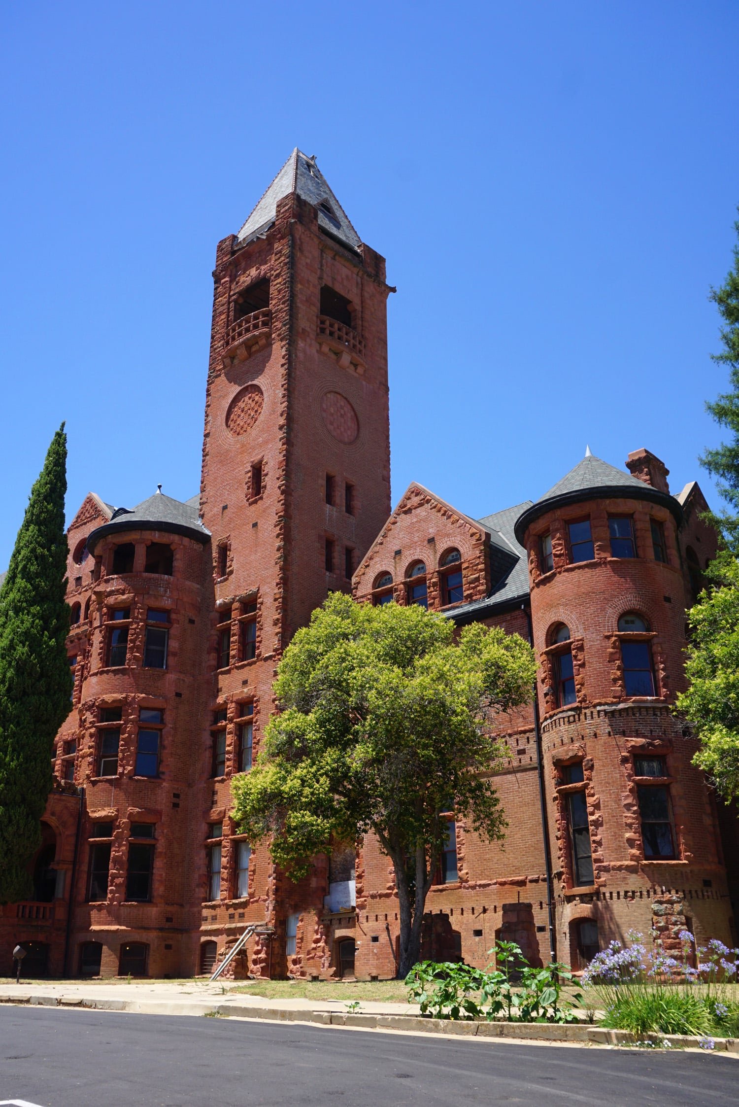 Preston Castle - large red brick building with plants and trees out front