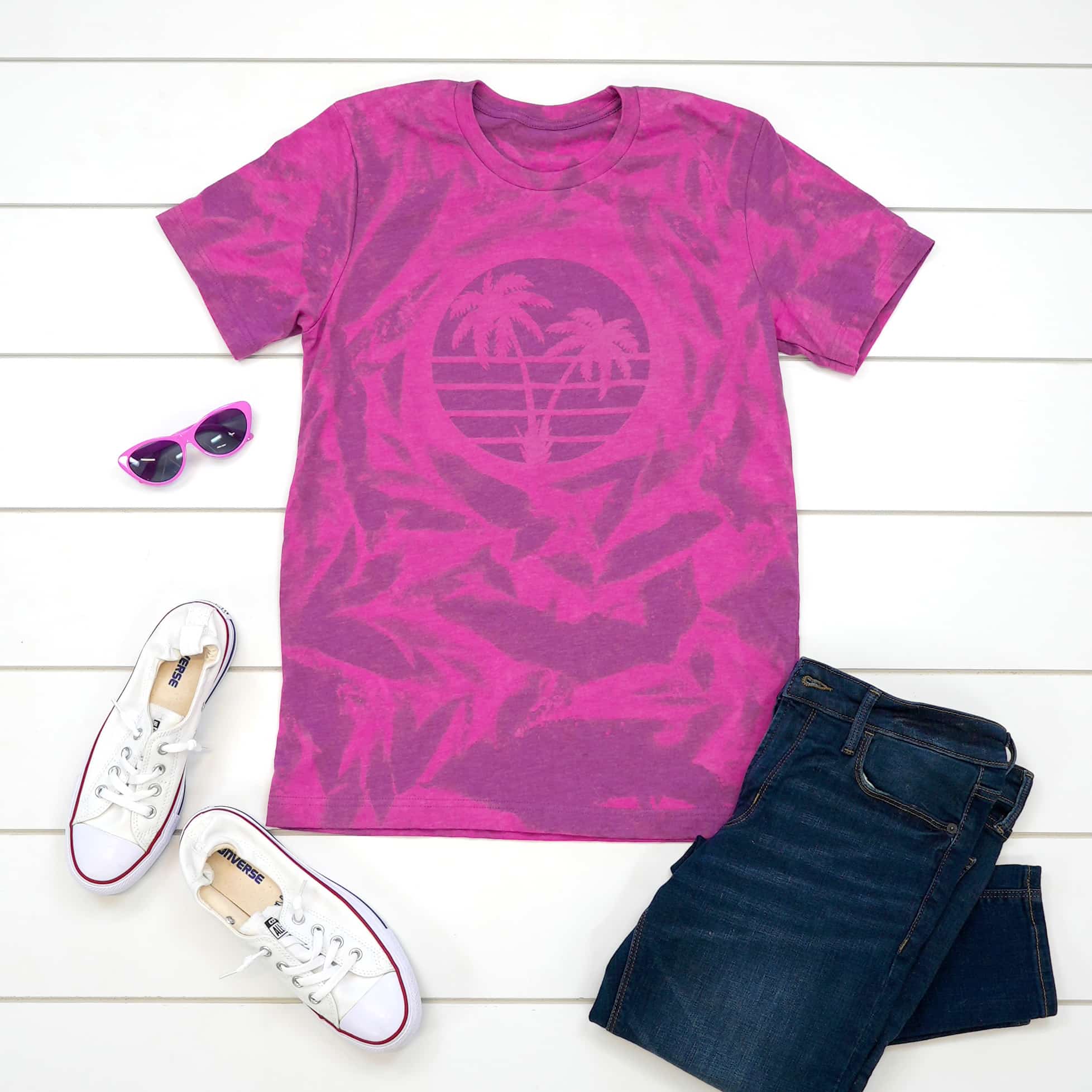 Pink and purple bleach dyed shirt with an outfit in flat lay on white wood background