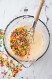 adding fruit pebbles cereal to mixing bowl