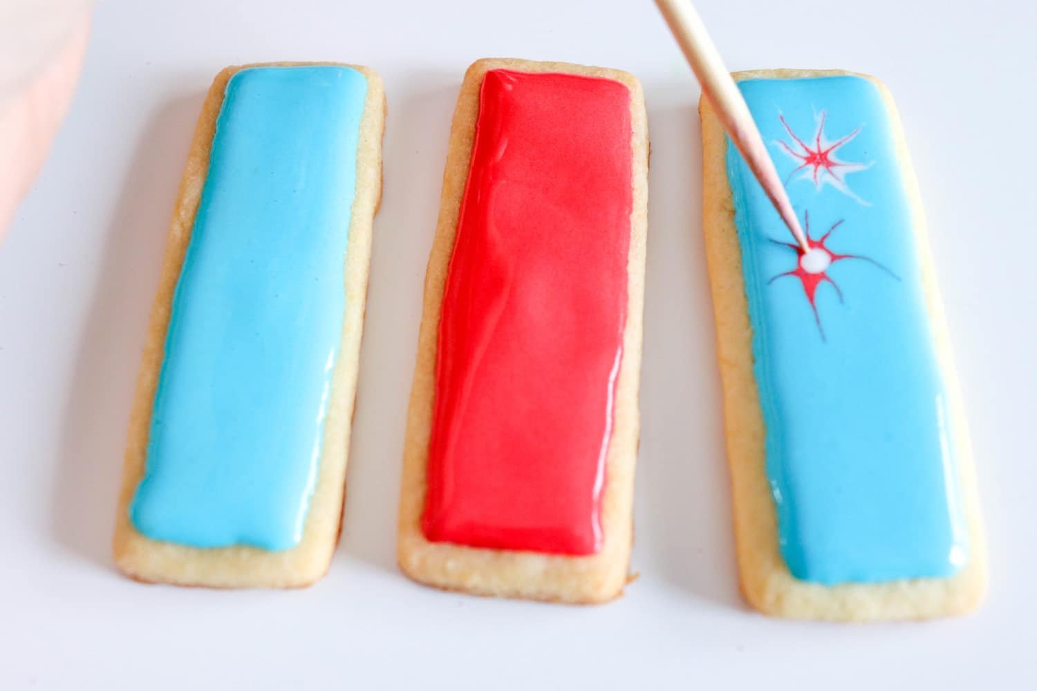 toothpick making design on independence day cookies