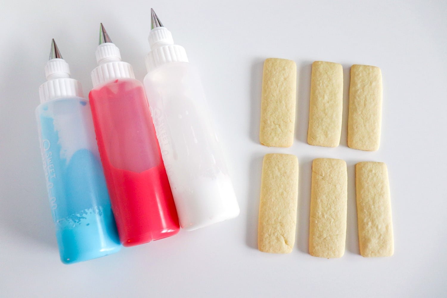 cut out rectangle sugar cookies and red white and blue icing bottles