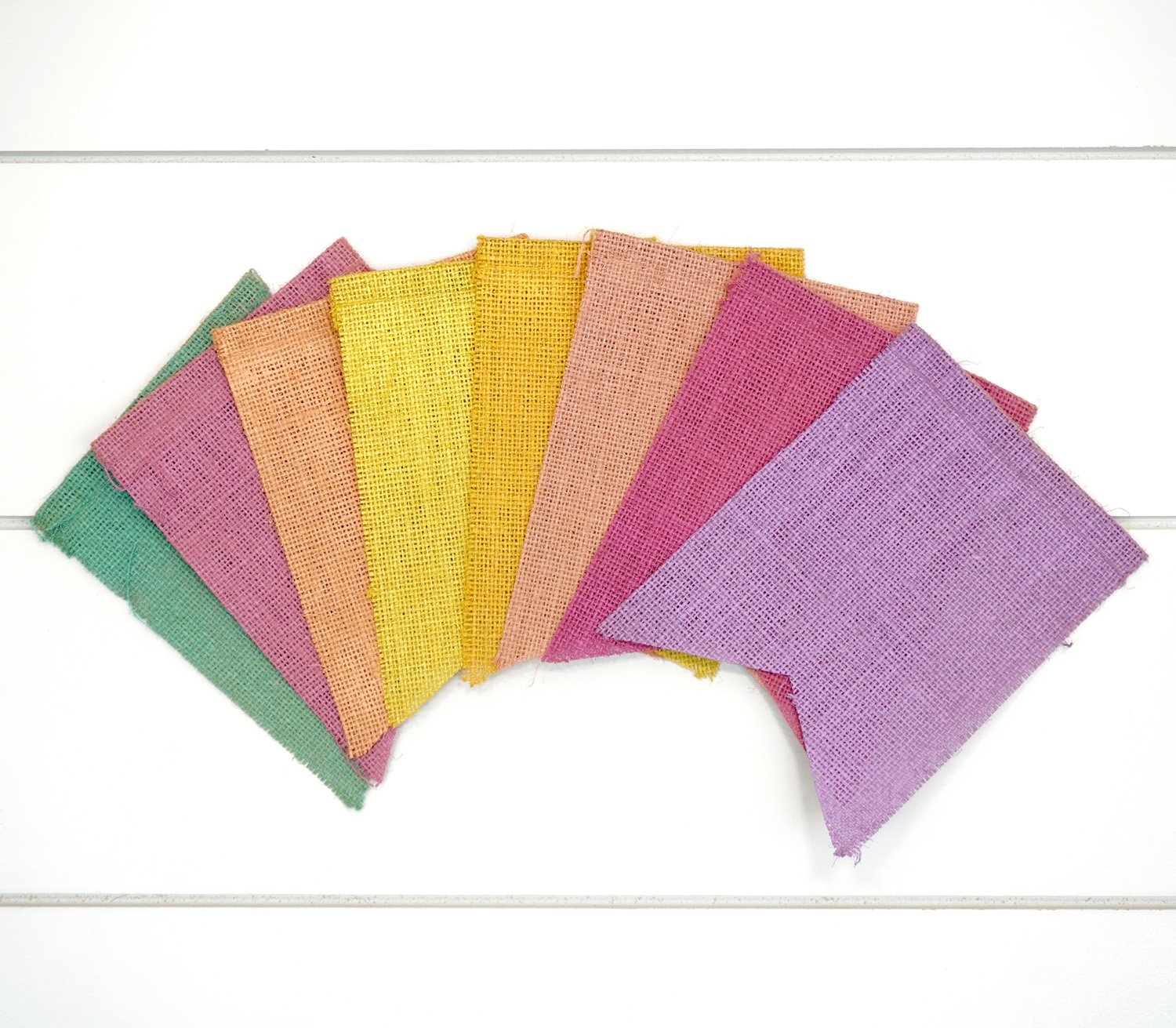 8 colorful burlap banner pieces fanned out on a white background
